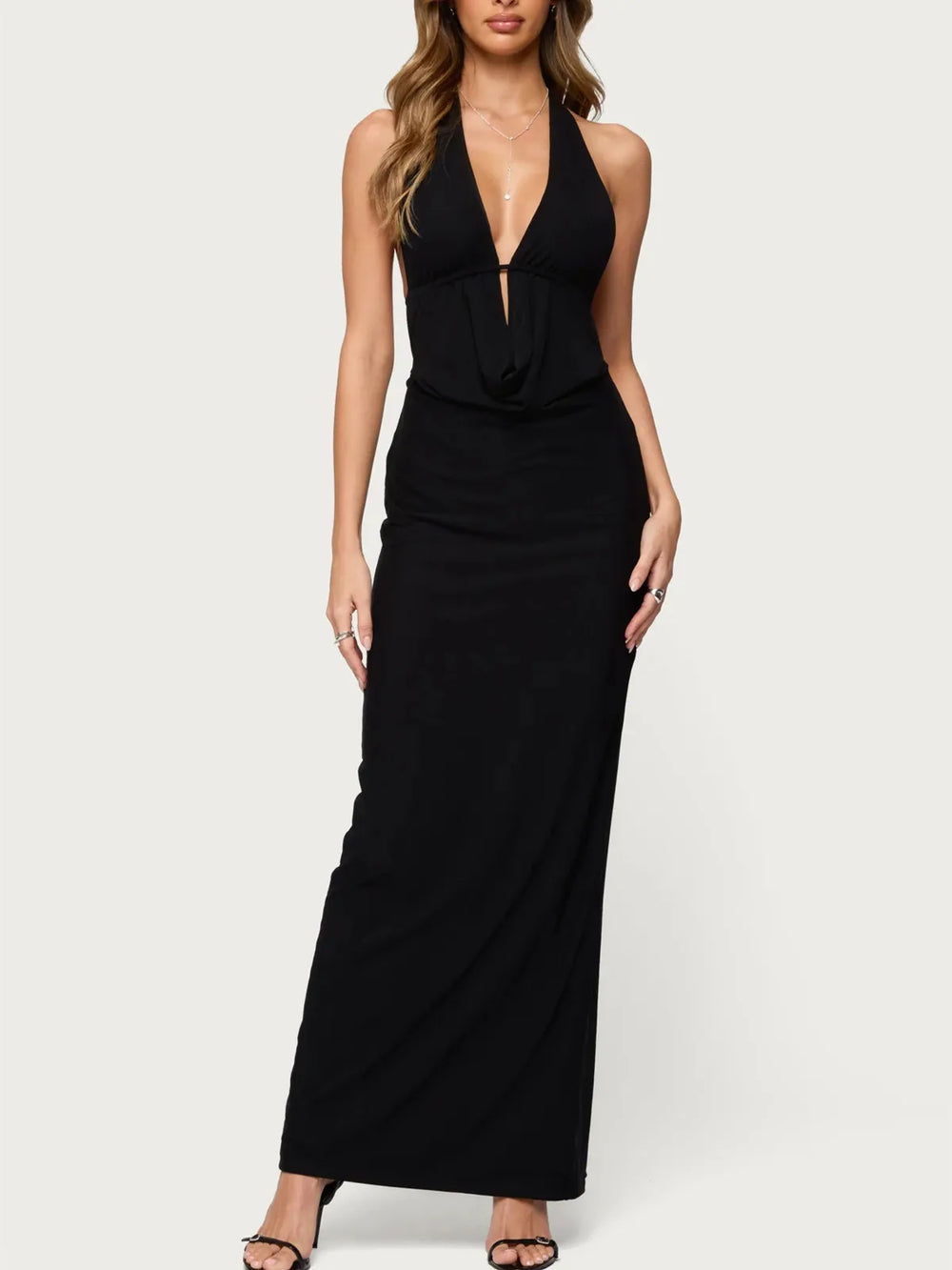 Black halter neck dress worn by a model on a white background