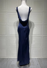 Navy blue evening gown on a mannequin against a white paneled wall.
