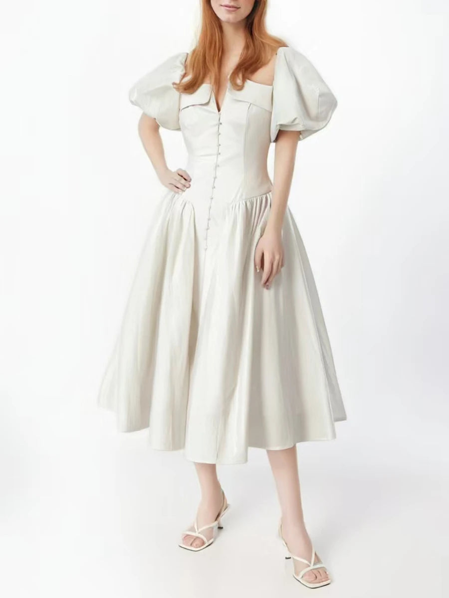 Woman wearing a white dress with puff sleeves on a white background