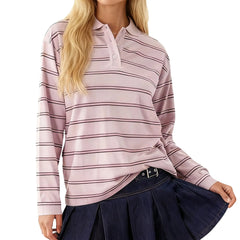 Woman wearing a pink and white striped long-sleeve shirt with a navy skirt on a white background