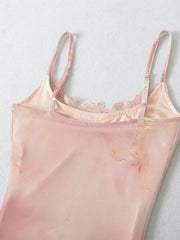 Close-up detail of the lace trim and spaghetti straps on a pink tulle gown.