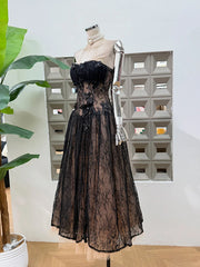 Black lace dress on a mannequin against a geometric wall pattern
