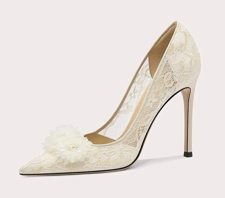 White lace high-heeled shoe with a decorative bow on a light gray background