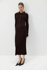 Model posing in brown ribbed knit polo top and midi skirt