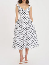Flowing polka dot midi dress displayed with elegant V-neck silhouette.