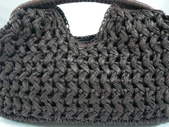 Close-up of a woven brown handbag on a white background