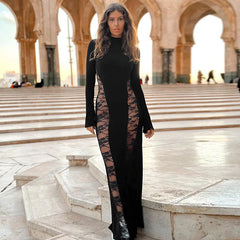 Woman wearing a black dress with lace panels in front of architectural columns.