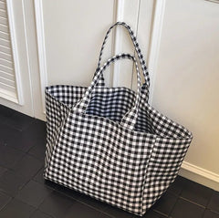 Black and white checkered tote bag on a tiled floor