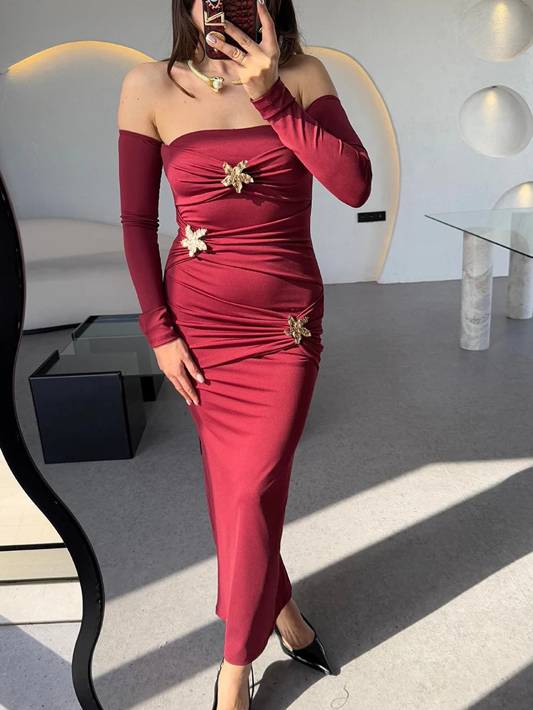 Red off-shoulder dress with gold embellishments worn by a person in a modern interior setting.