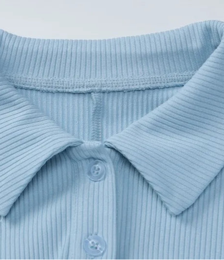Close-up of a light blue ribbed polo shirt collar on a white background