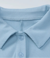 Close-up of a light blue ribbed polo shirt collar on a white background
