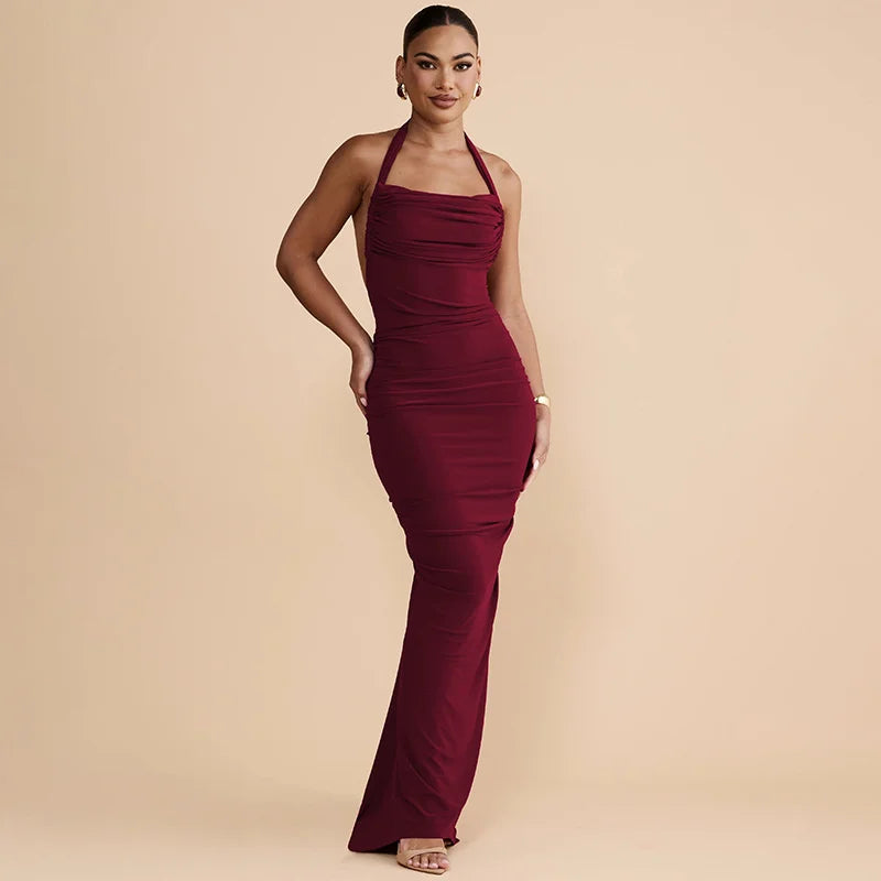 Woman wearing a burgundy halter neck dress on a beige background