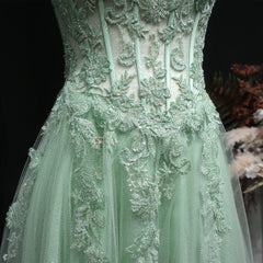 Mint green lace dress with intricate detailing on a dark background