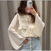 Floral embroidered blouse with flared sleeves and mini skirt.