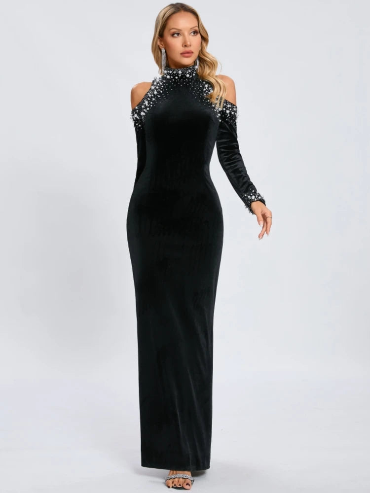 Black evening gown with long sleeves and embellishments on a white background