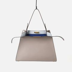 Leather trapezoid top handle bag with a blue interior.