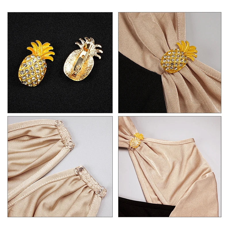Gold pineapple-shaped hair accessories on a black background and beige fabric.