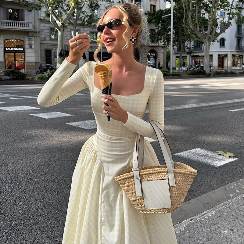 Woman in a white dress eating ice cream on a city street