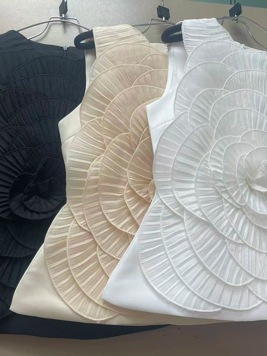 Three sleeveless tops in black, beige, and white on hangers against a neutral background.