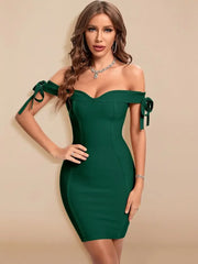 Woman wearing a green off-shoulder dress with ribbons on a beige background