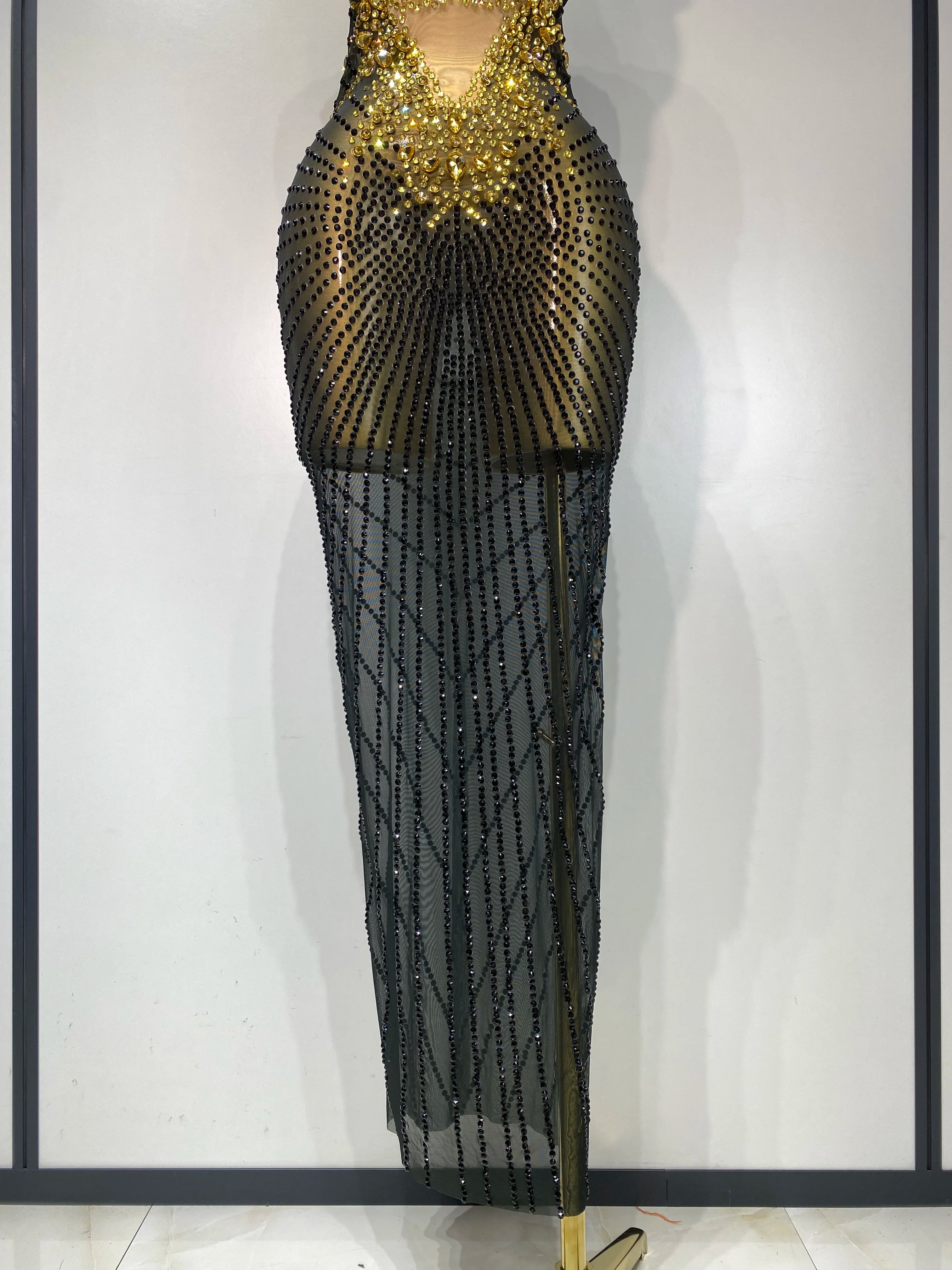 Black beaded evening gown on a mannequin against a white background