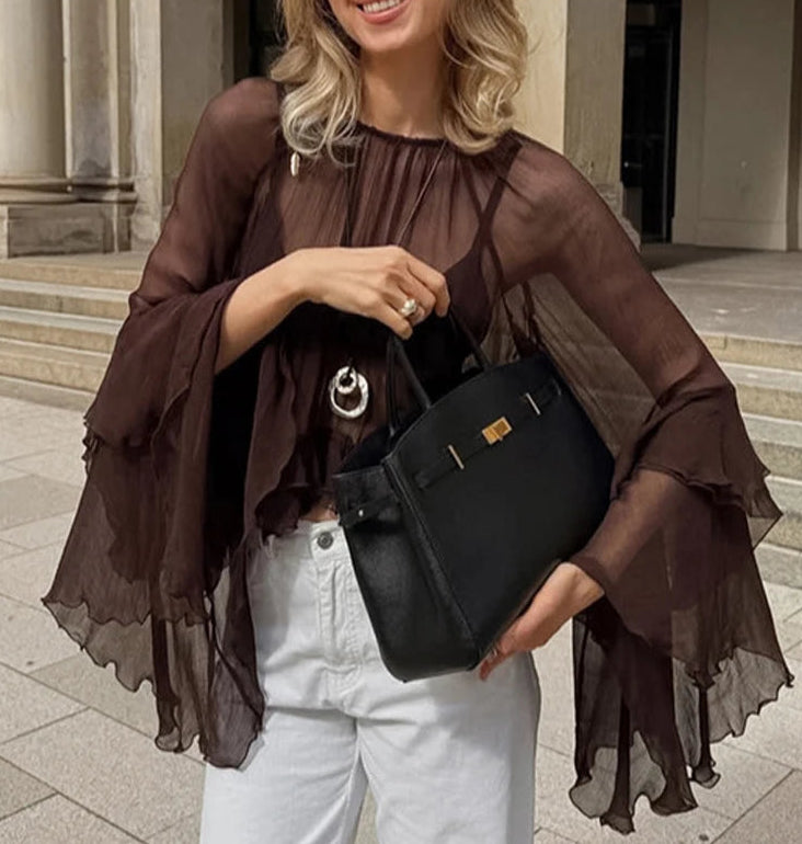 Woman holding a black handbag in an urban setting