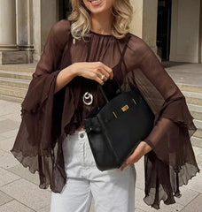 Woman holding a black handbag in an urban setting