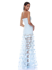 Woman wearing a light blue evening gown with a unique design on a white background