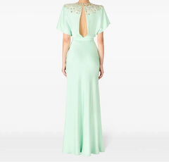 Mint green evening gown with open back on a white background