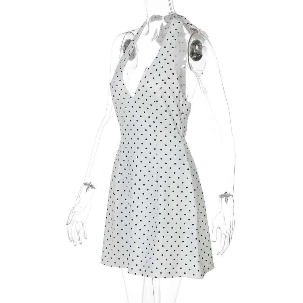 White dress with black polka dots on a mannequin against a white background