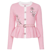 Pink embroidered peplum knit cardigan with a white trim and belt.