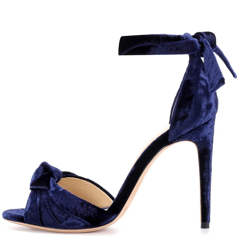 Side view of a blue velvet bow tie ankle strap high heel sandal