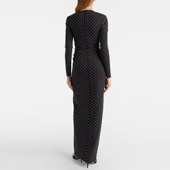 Back view of a woman wearing a black beaded polka dot maxi dress.