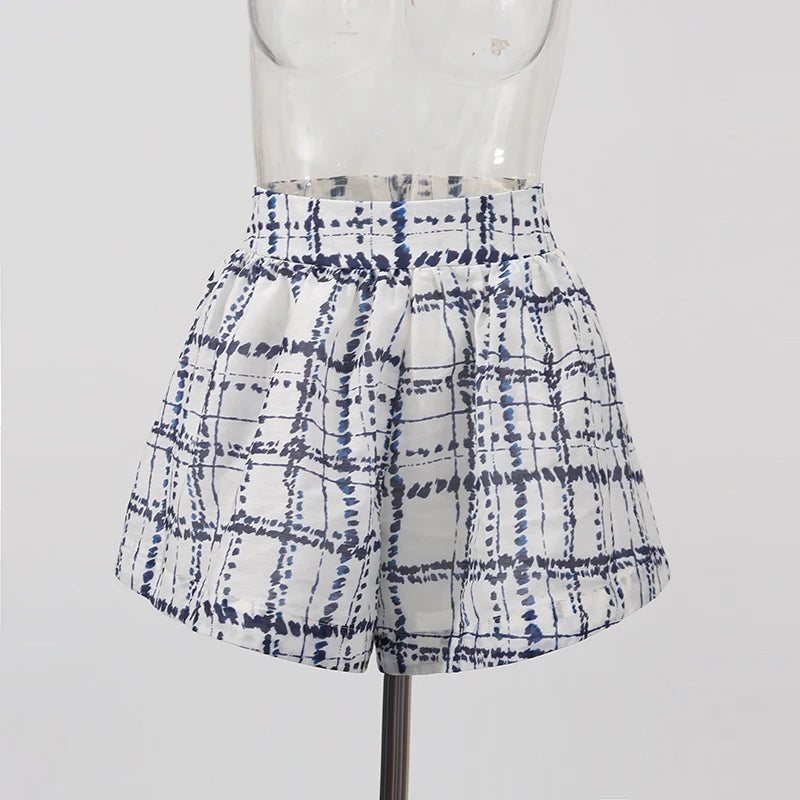 White shorts with blue tie-dye pattern on a mannequin against a white background