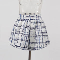 White shorts with blue tie-dye pattern on a mannequin against a white background