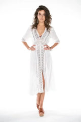 White midi dress with lace trim and V-neck, hands on hips.