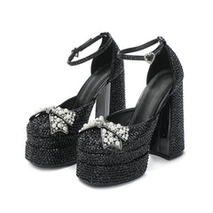 Black high-heeled shoes with crystal embellishments on a white background