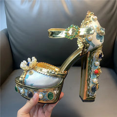 Decorative high-heeled shoe with gold accents and gemstones held by a hand.