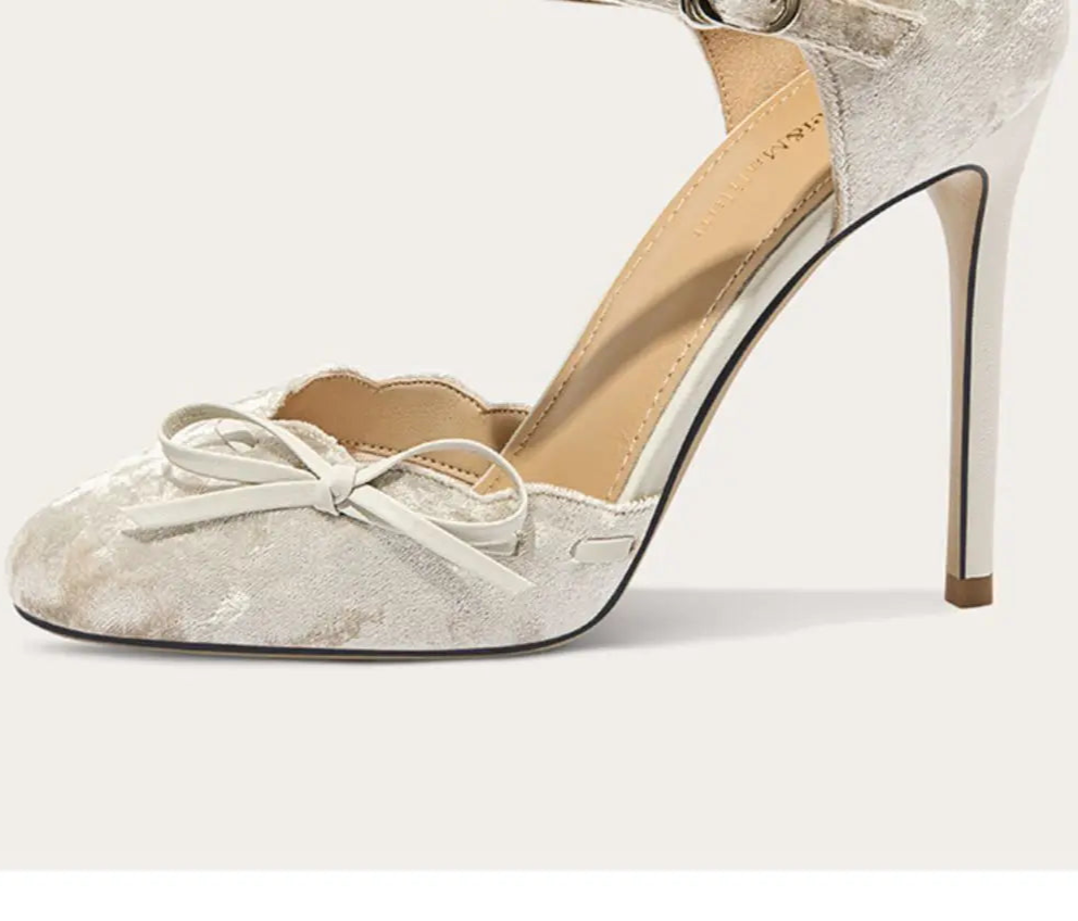 High-heeled shoe with a bow detail on a light background