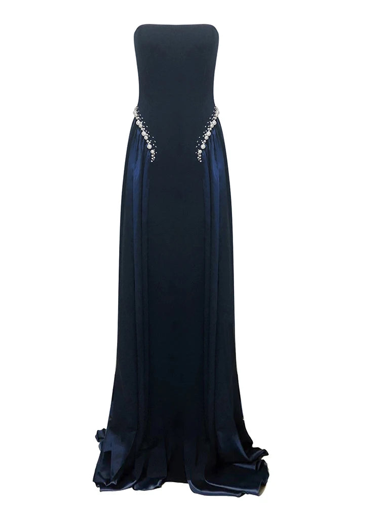 Navy blue strapless evening gown with beaded detailing on a white background