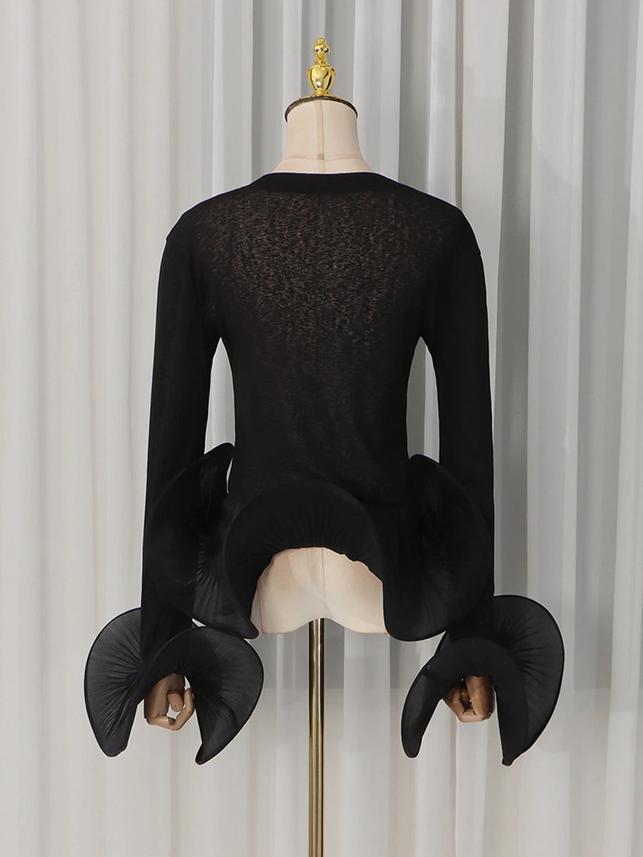 Back view of the black sheer knit top with pleated flare sleeves