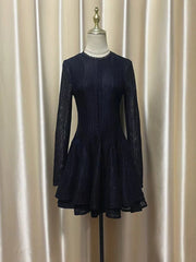 Navy blue dress on a mannequin against a beige curtain background