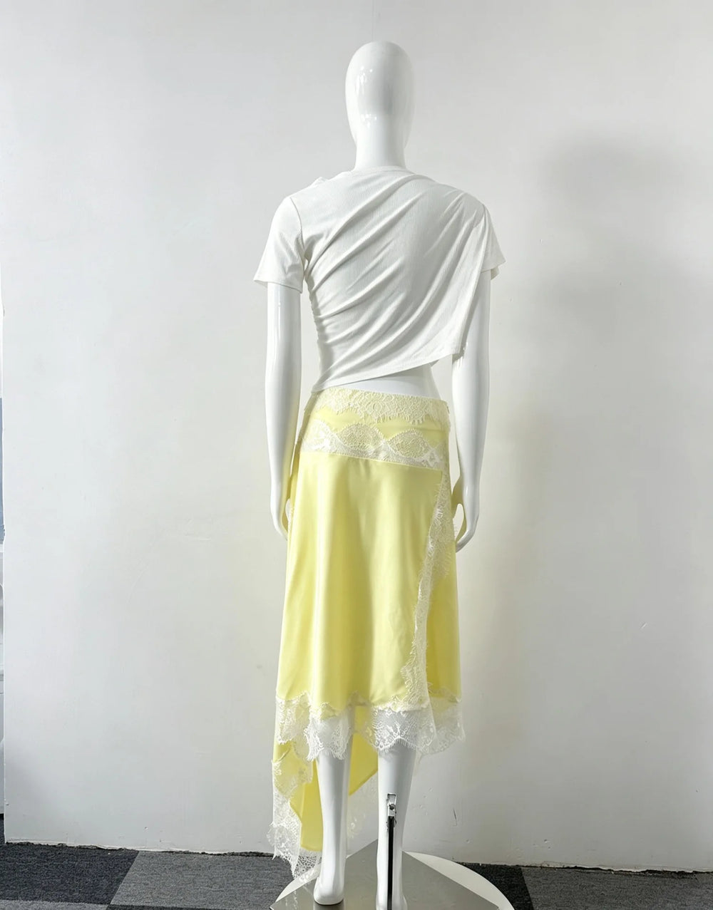 Back view of yellow variant cutout lace trim asymmetrical dress on mannequin