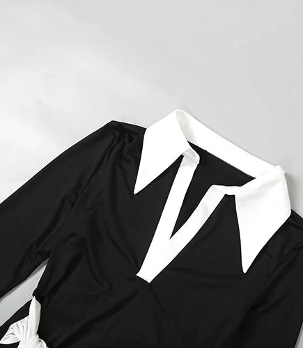 Black outfit with white collar on a light gray background