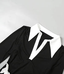 Black outfit with white collar on a light gray background