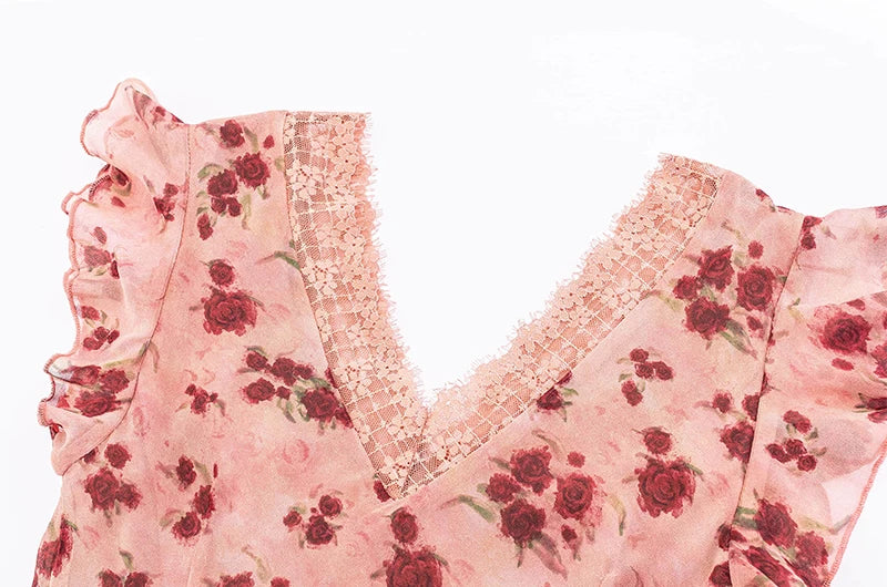 Close-up of the V-neckline and flutter sleeves of a pink floral print dress, showing lace trim detail.