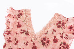 Close-up of the V-neckline and flutter sleeves of a pink floral print dress, showing lace trim detail.