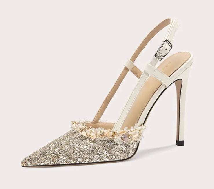 High-heeled shoe with glittery sole on a white background