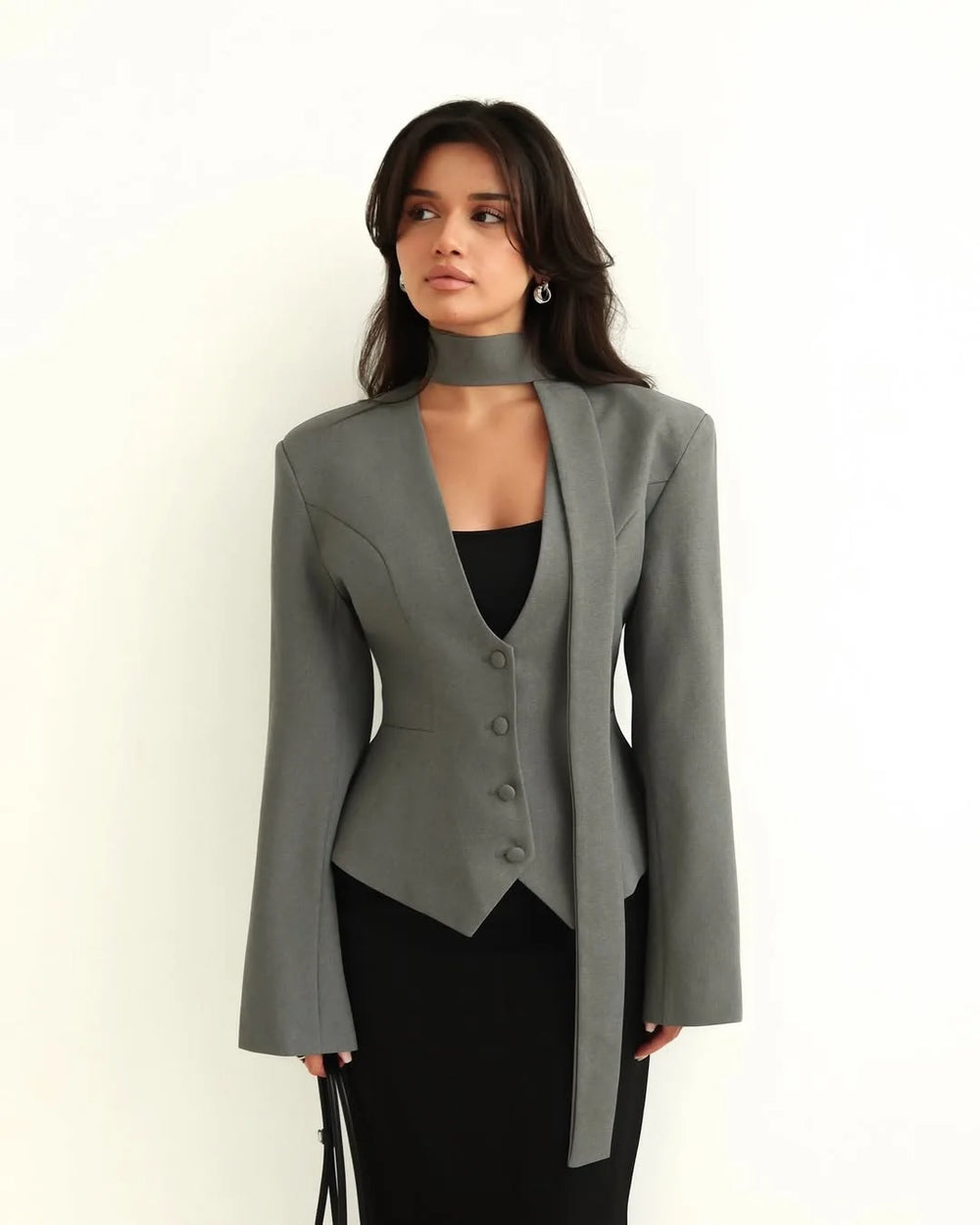 Woman wearing a gray blazer over a black top on a white background