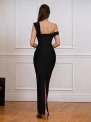 Woman wearing a black off-shoulder dress with a high slit in a room with white paneled walls.